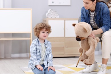 Photo of Resentful little boy and his mother arguing at home