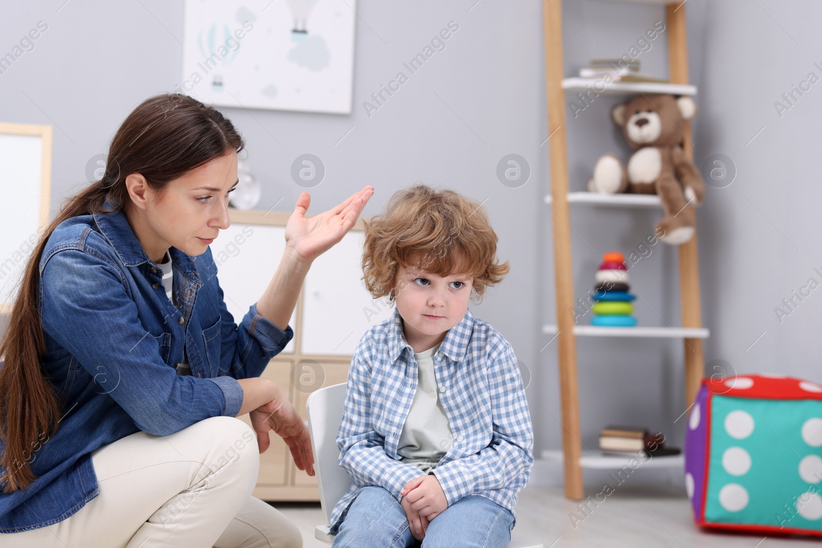 Photo of Resentful little boy and his mother arguing at home