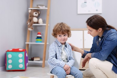 Photo of Resentful little boy and his mother arguing at home