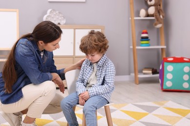 Photo of Resentful little boy and his mother at home, space for text. Family dispute