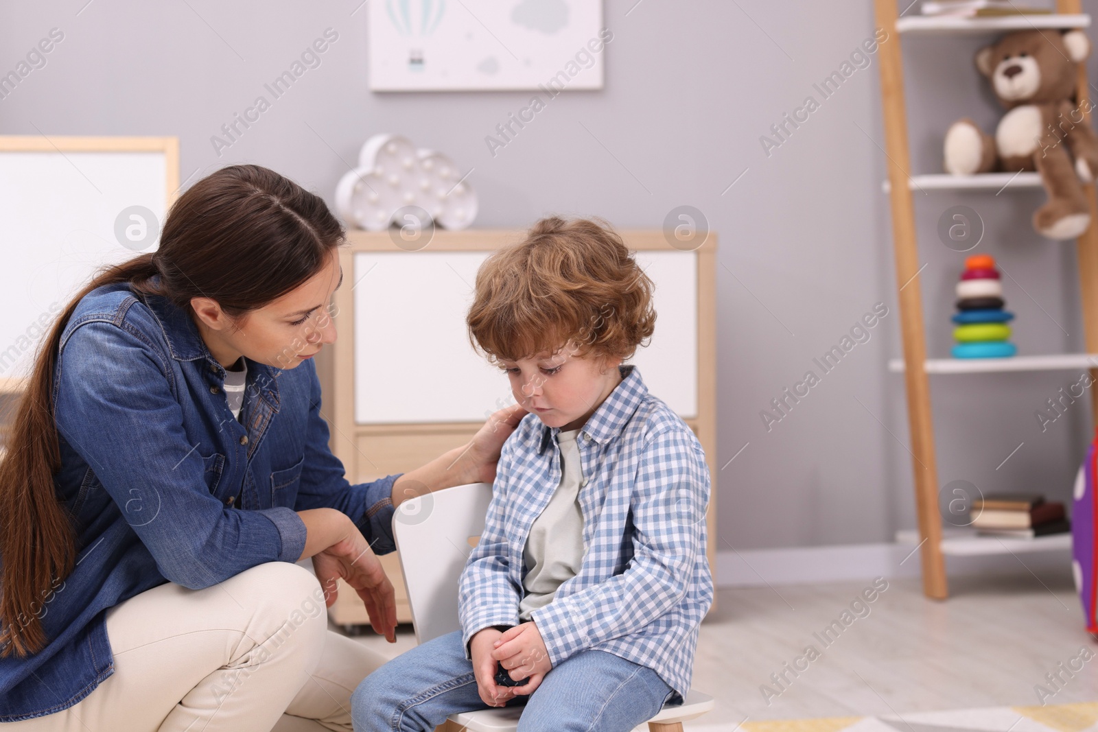 Photo of Resentful little boy and his mother at home, space for text. Family dispute