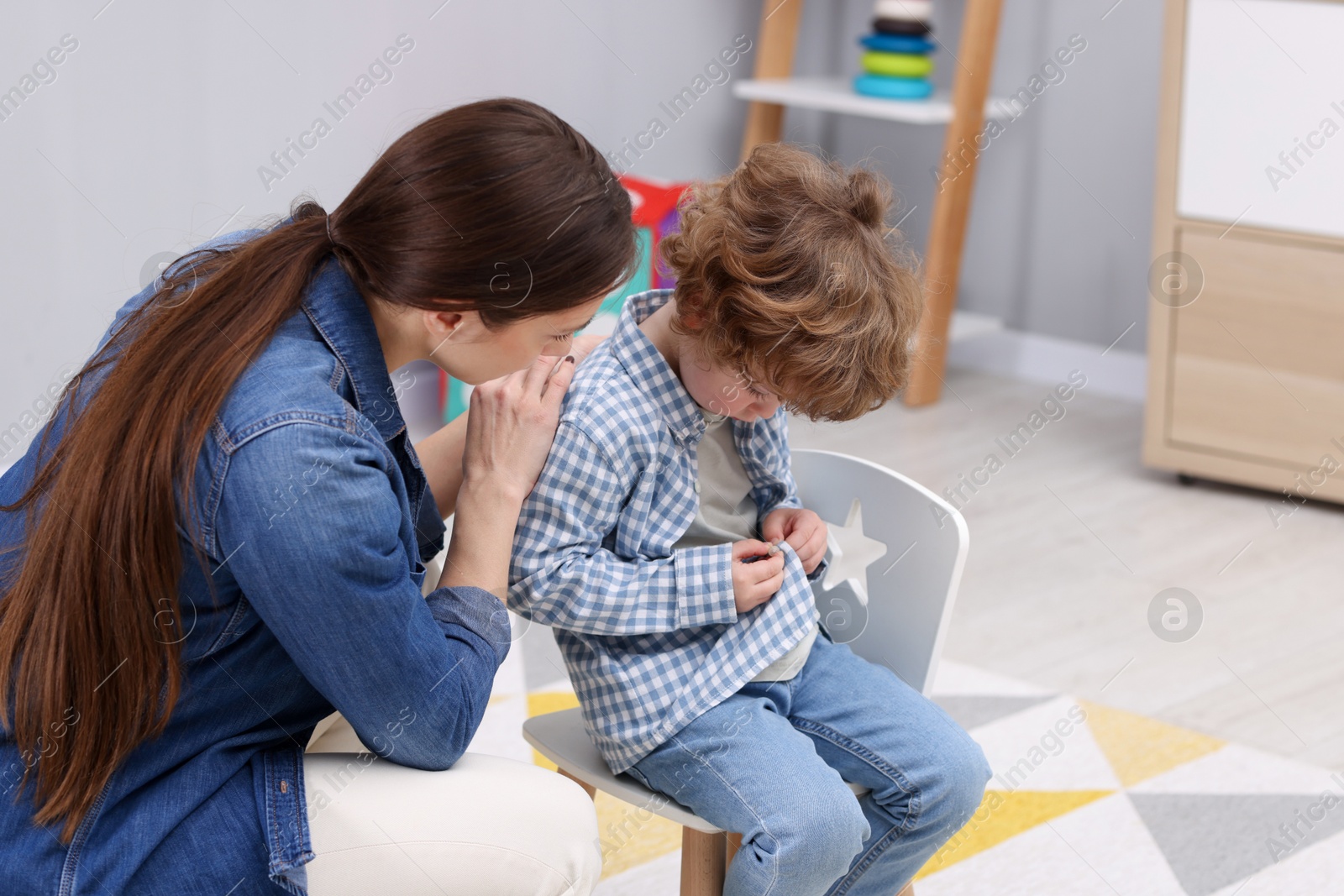 Photo of Resentful little boy and his mother at home. Family dispute