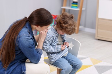 Photo of Resentful little boy and his mother at home. Family dispute