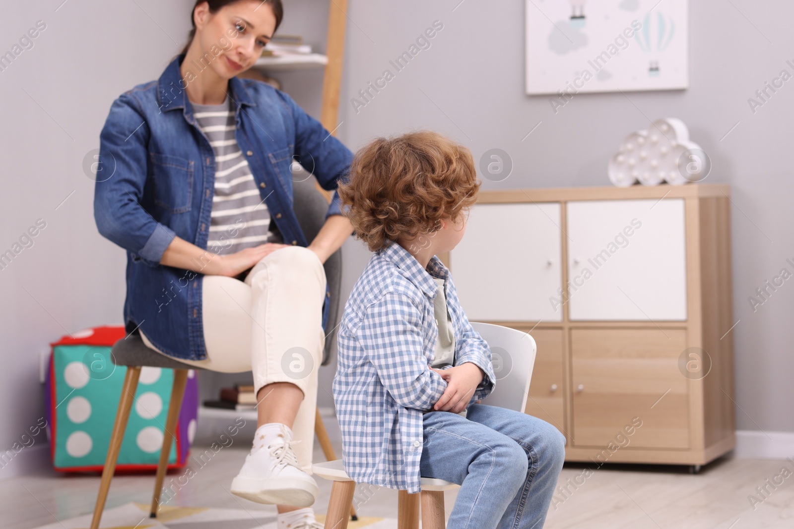 Photo of Resentful little boy and his mother at home. Family dispute