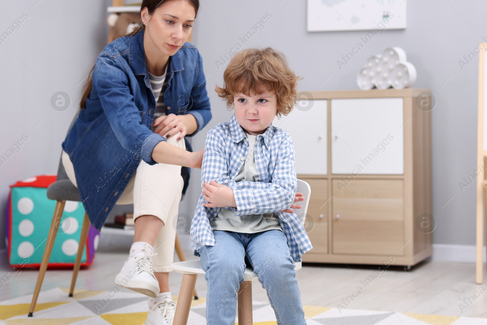 Photo of Resentful little boy and his mother arguing at home