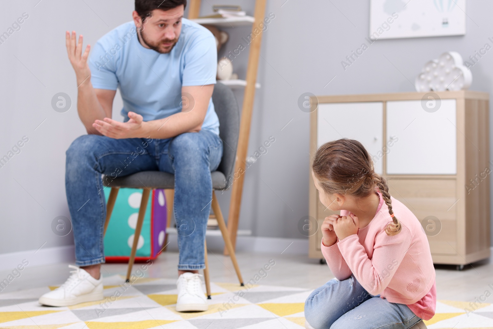 Photo of Resentful little girl and her father arguing at home