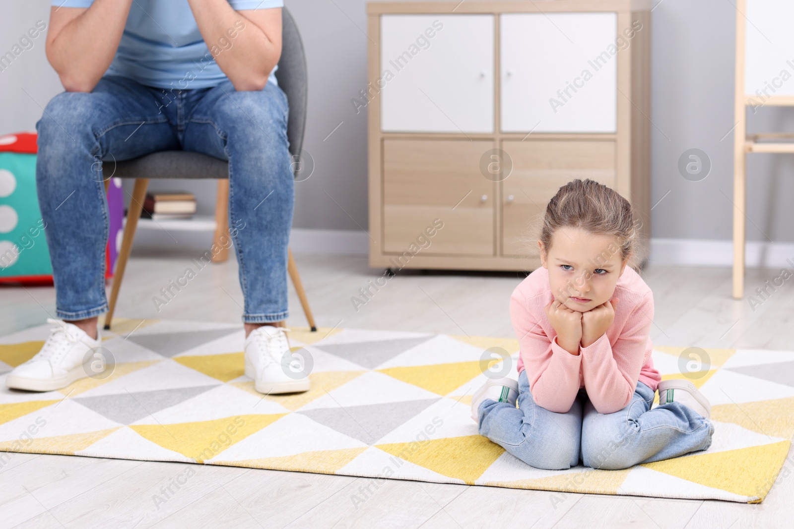 Photo of Resentful little girl and her father at home. Family dispute