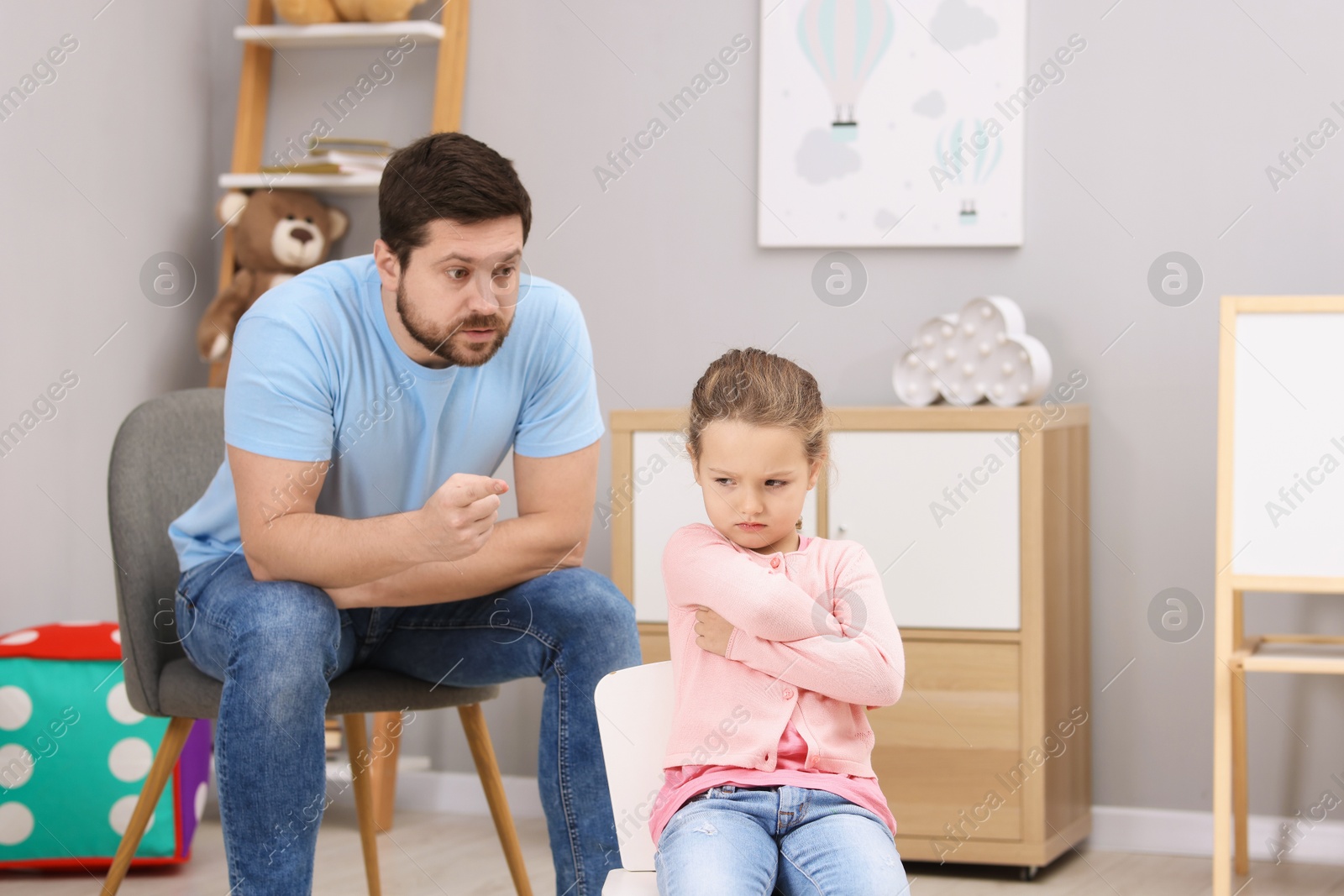 Photo of Resentful little girl and her father arguing at home