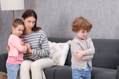 Photo of Resentful little kids and their mother arguing at home