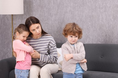 Photo of Resentful little kids and their mother arguing at home