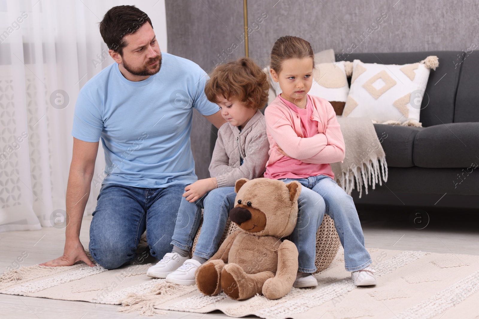 Photo of Resentful little kids and their father arguing at home