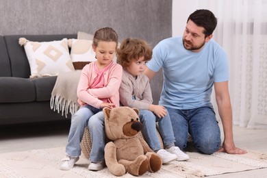 Photo of Resentful little kids and their father arguing at home