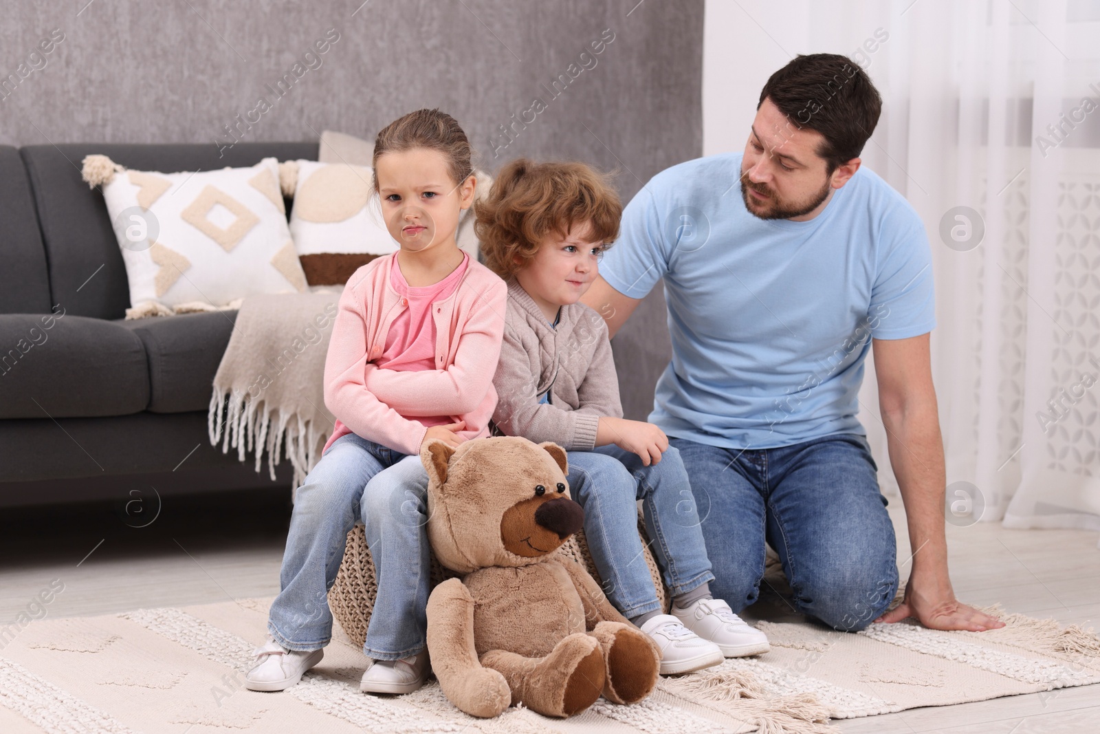 Photo of Resentful little kids and their father arguing at home