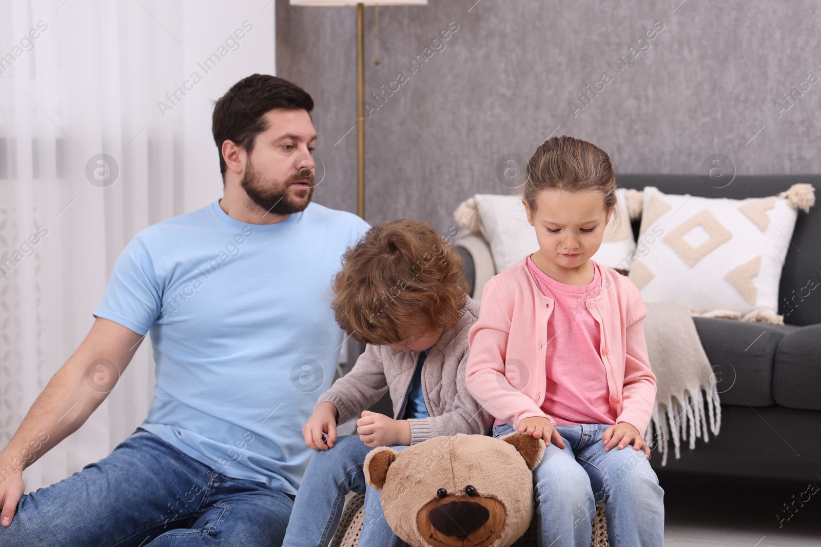 Photo of Resentful little kids and their father arguing at home