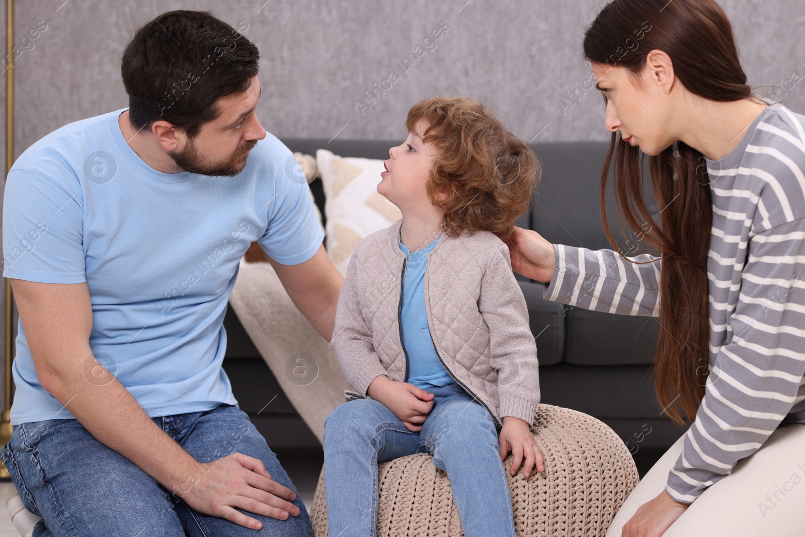 Photo of Resentful little boy and his parents arguing at home