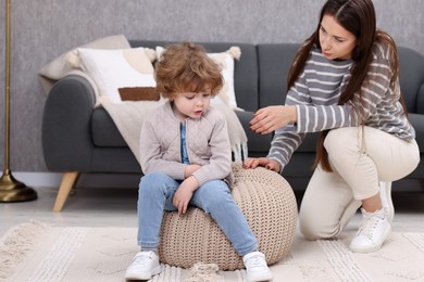 Photo of Resentful little boy and his mother arguing at home