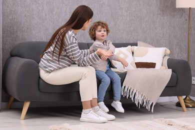 Photo of Resentful little boy and his mother arguing at home