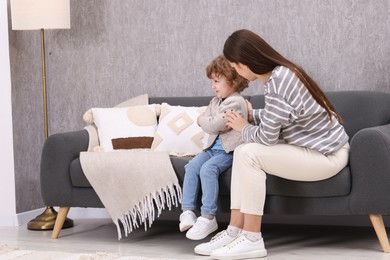 Photo of Resentful little boy and his mother arguing at home