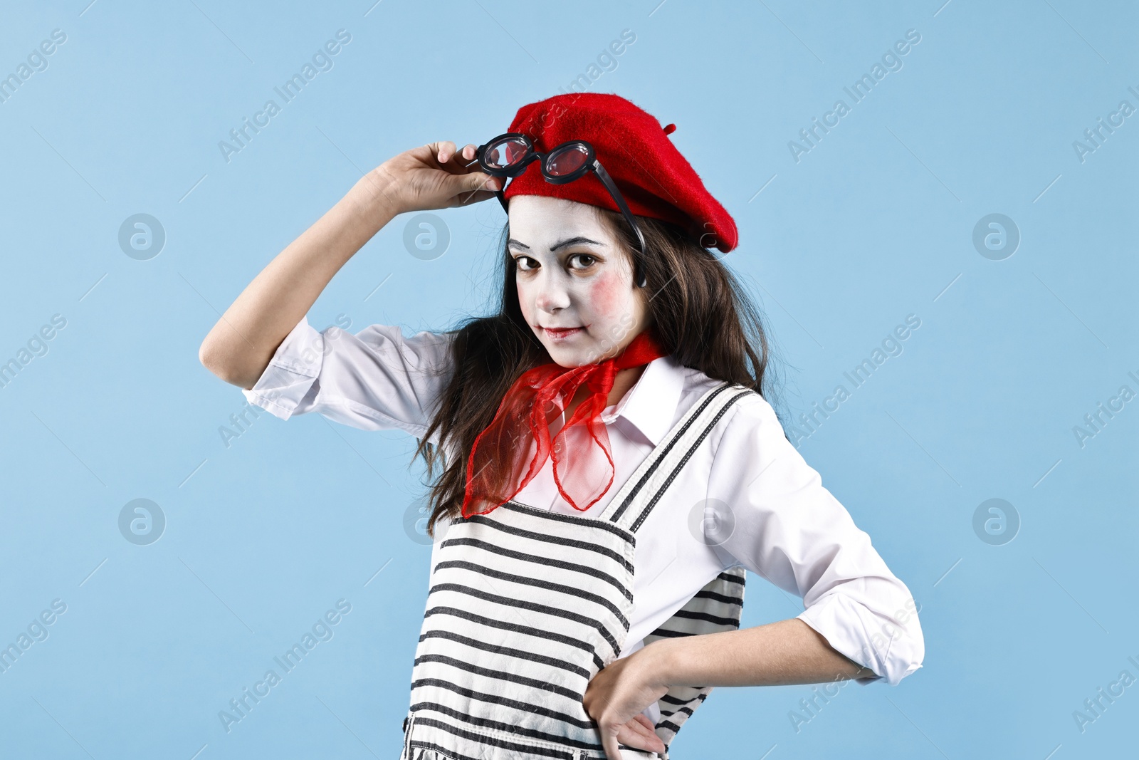 Photo of Cute girl dressed like mime on light blue background. Surprise party