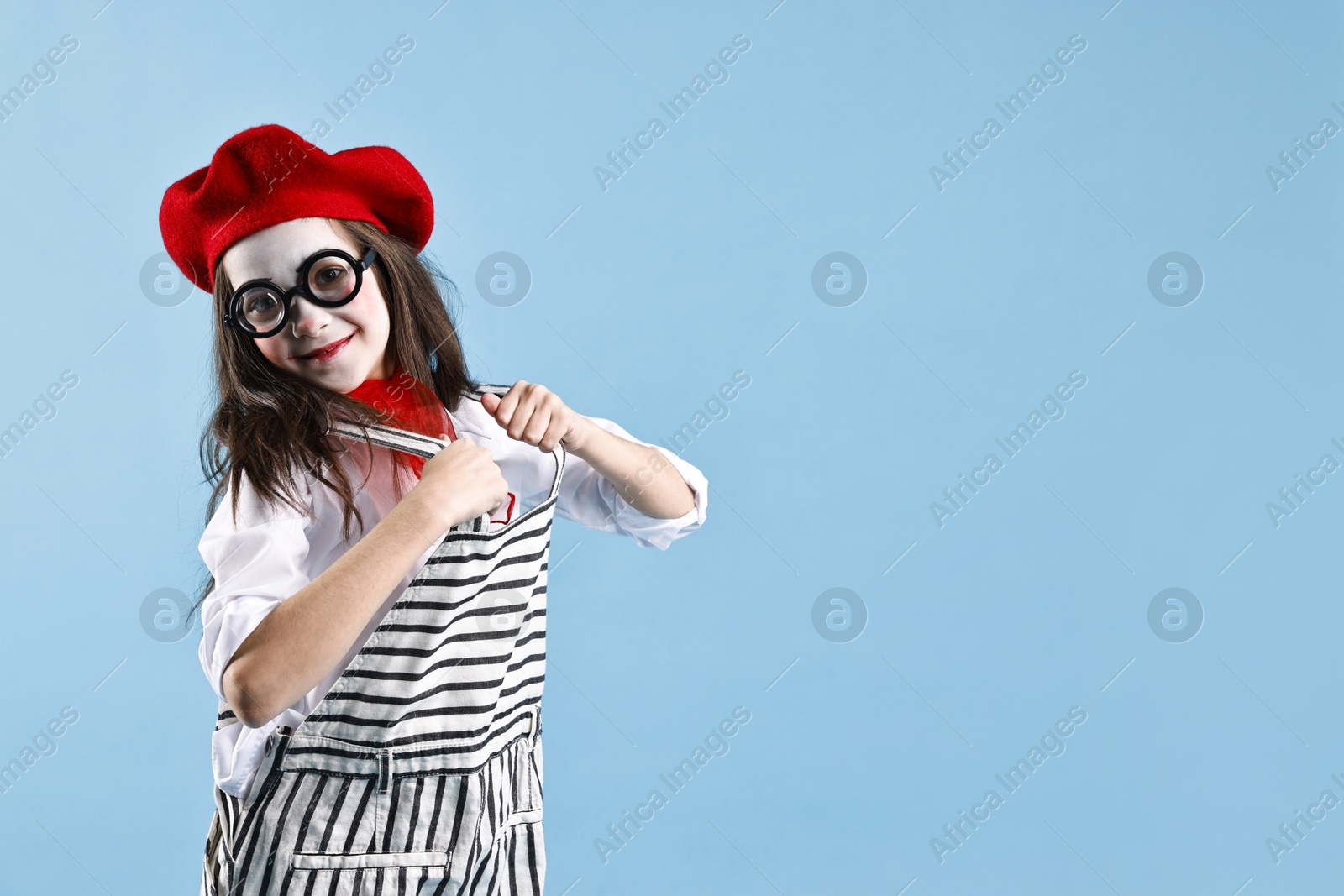 Photo of Cute girl dressed like mime on light blue background, space for text. Surprise party