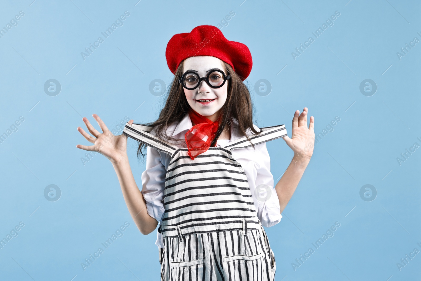 Photo of Happy girl dressed like mime on light blue background. Surprise party