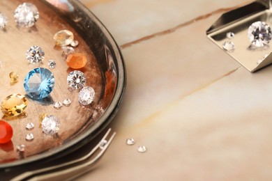 Photo of Tray with beautiful gemstones and tweezers on light table, closeup. Space for text