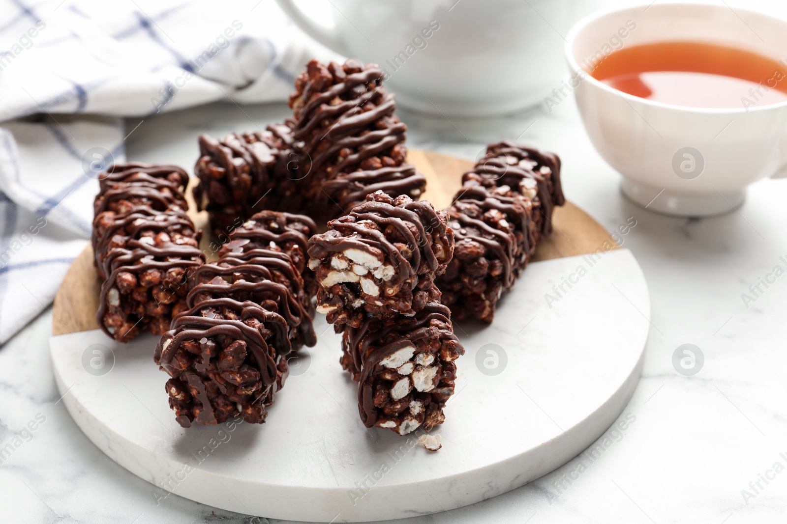 Photo of Delicious chocolate puffed rice bars on white marble table, closeup