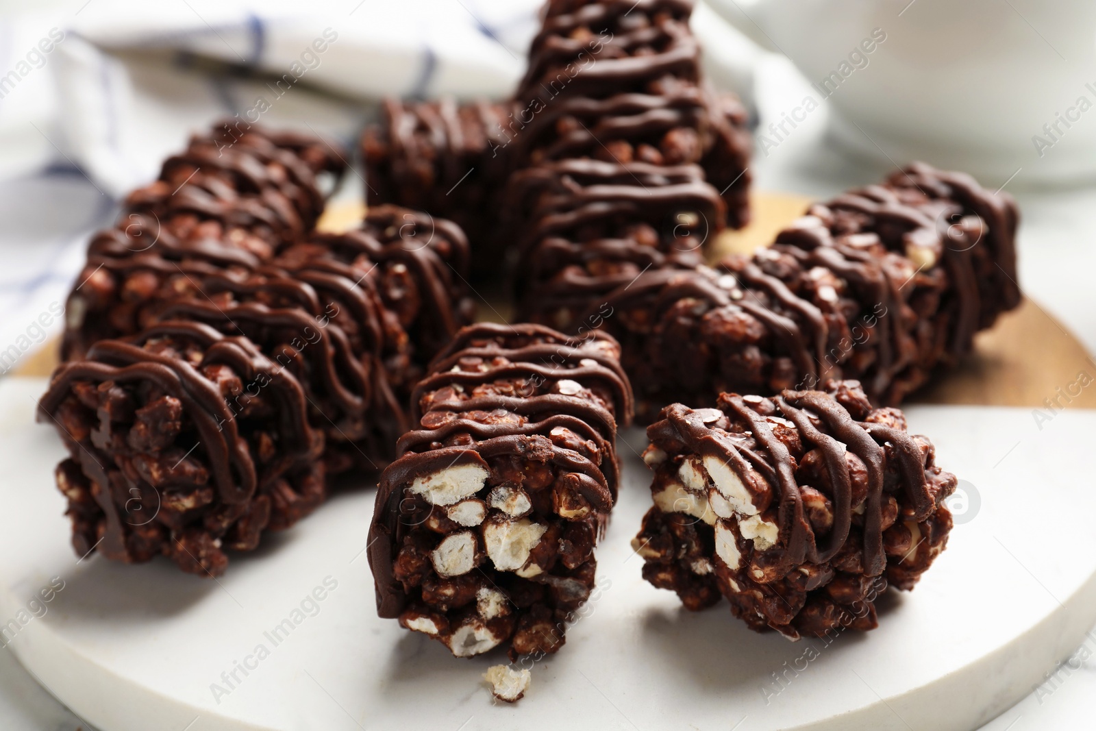 Photo of Delicious chocolate puffed rice bars on white marble table, closeup