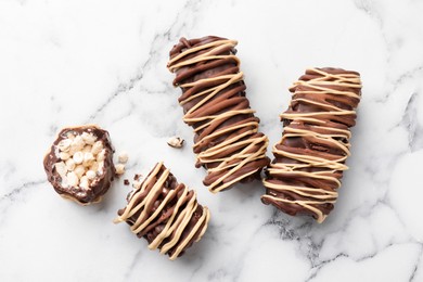 Photo of Delicious chocolate puffed rice bars on white marble table, flat lay