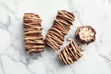 Photo of Delicious chocolate puffed rice bars on white marble table, flat lay