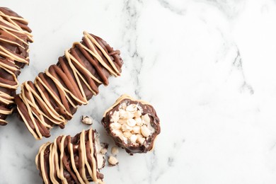 Photo of Delicious chocolate puffed rice bars on white marble table, flat lay. Space for text