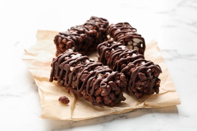 Photo of Delicious chocolate puffed rice bars on white marble table, closeup