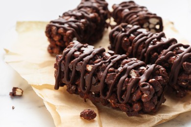 Photo of Delicious chocolate puffed rice bars on white marble table, closeup