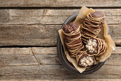 Photo of Delicious chocolate puffed rice bars on wooden table, top view. Space for text