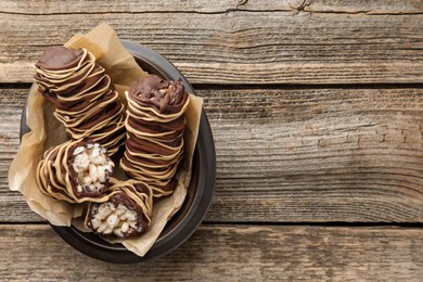 Photo of Delicious chocolate puffed rice bars on wooden table, top view. Space for text