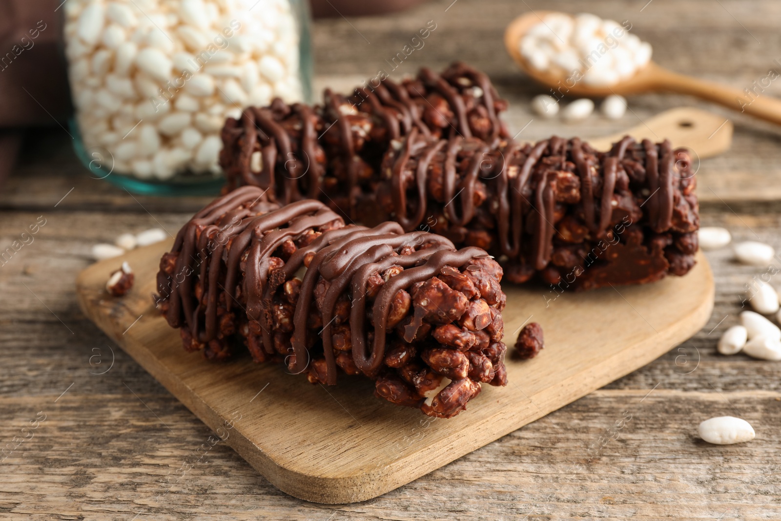 Photo of Delicious chocolate puffed rice bars on wooden table, closeup