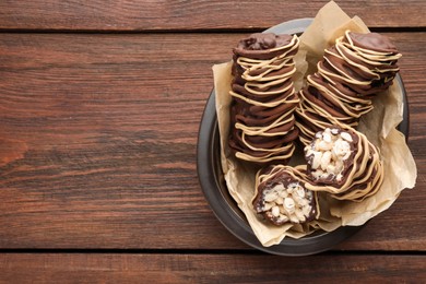 Photo of Delicious chocolate puffed rice bars on wooden table, top view. Space for text