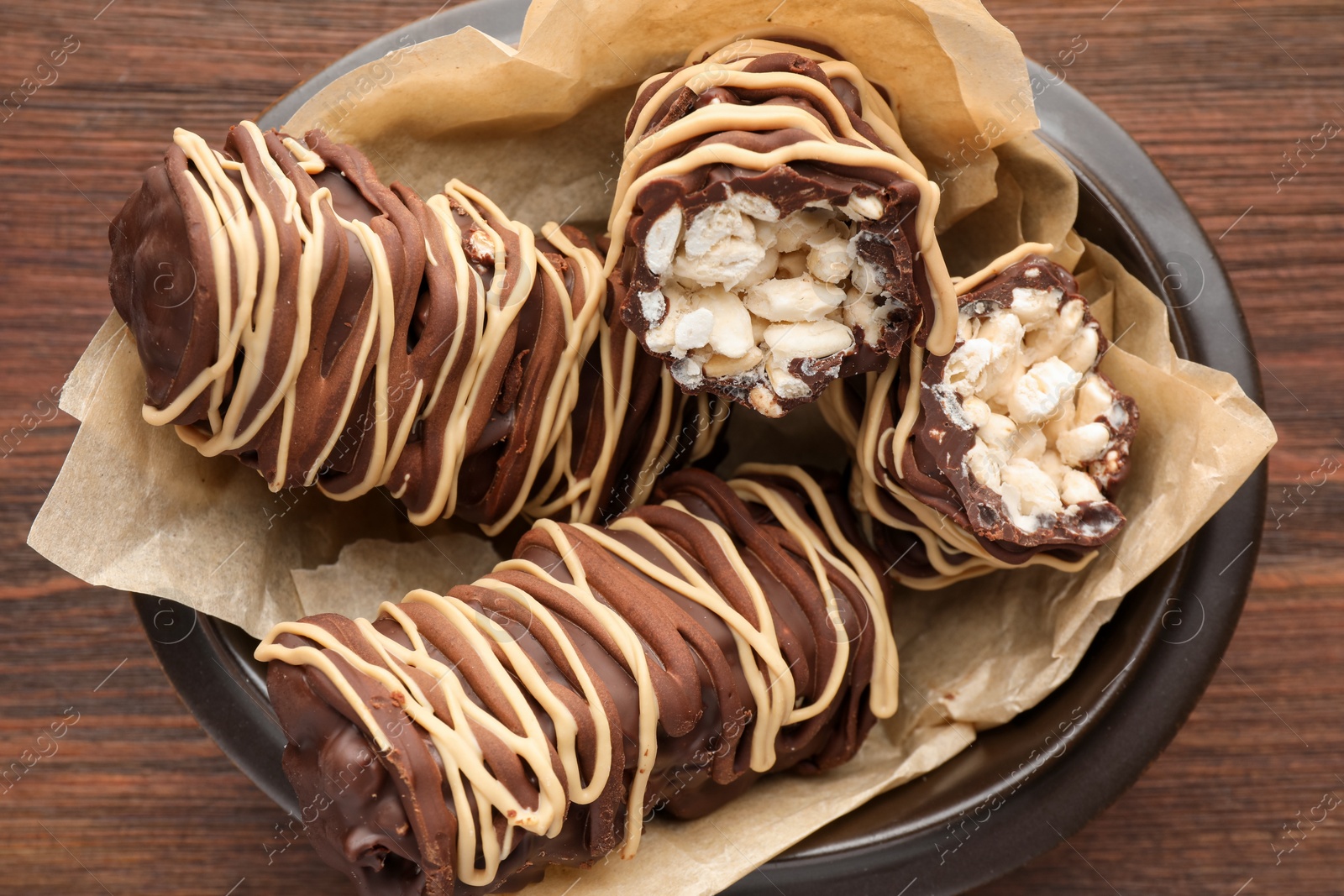 Photo of Delicious chocolate puffed rice bars on wooden table, top view