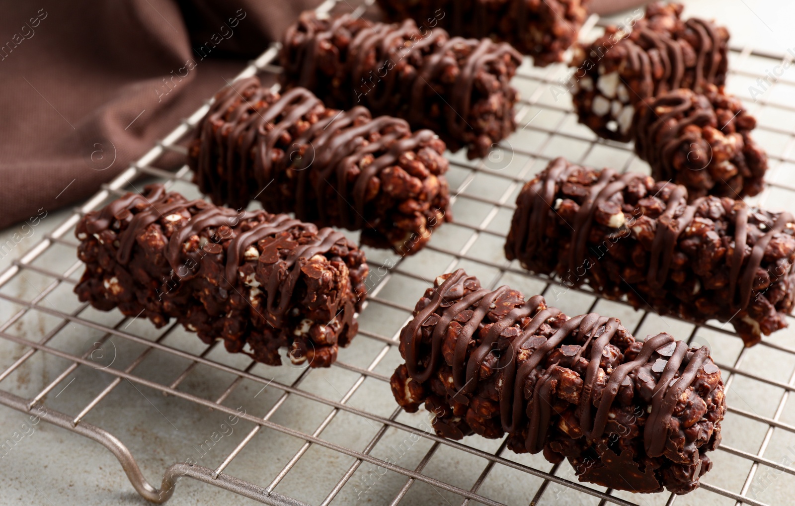 Photo of Delicious chocolate puffed rice bars on gray textured table, closeup