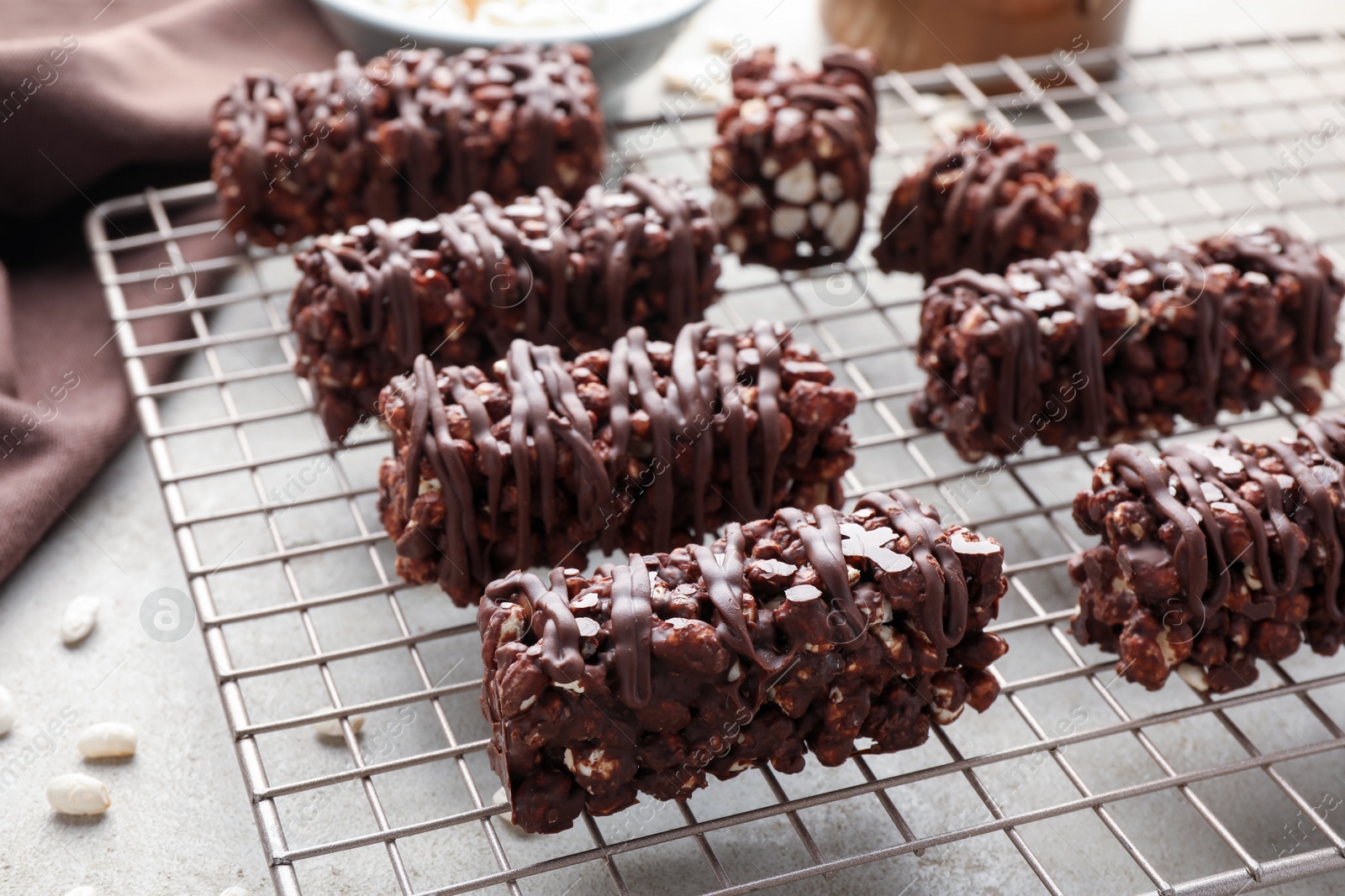 Photo of Delicious chocolate puffed rice bars on gray textured table, closeup