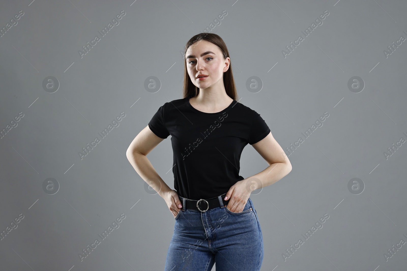 Photo of Beautiful young woman in stylish jeans on grey background