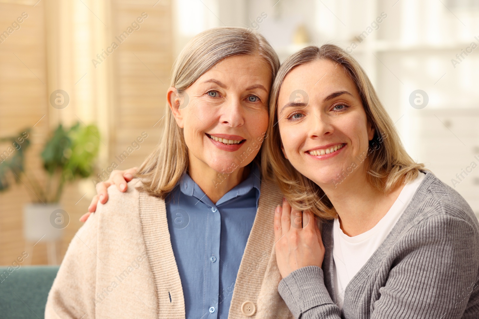 Photo of Family portrait of smiling mother and her daughter at home