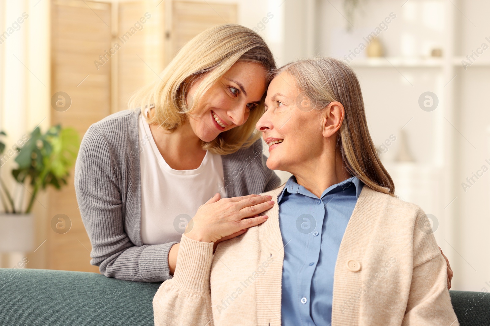 Photo of Smiling daughter and her mother at home