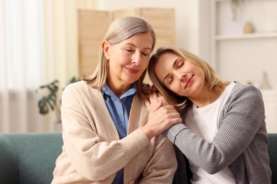 Photo of Daughter and her mother on sofa at home