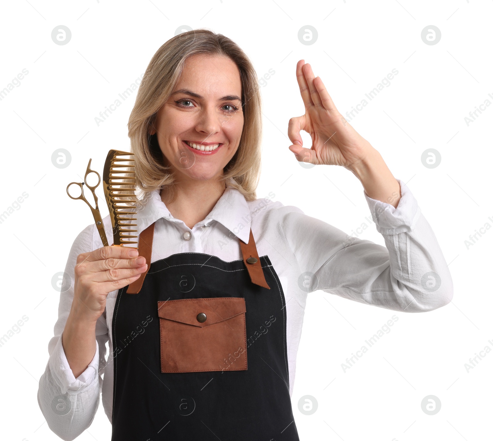 Photo of Smiling hairdresser with comb and scissors showing OK gesture on white background