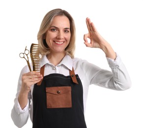 Photo of Smiling hairdresser with comb and scissors showing OK gesture on white background