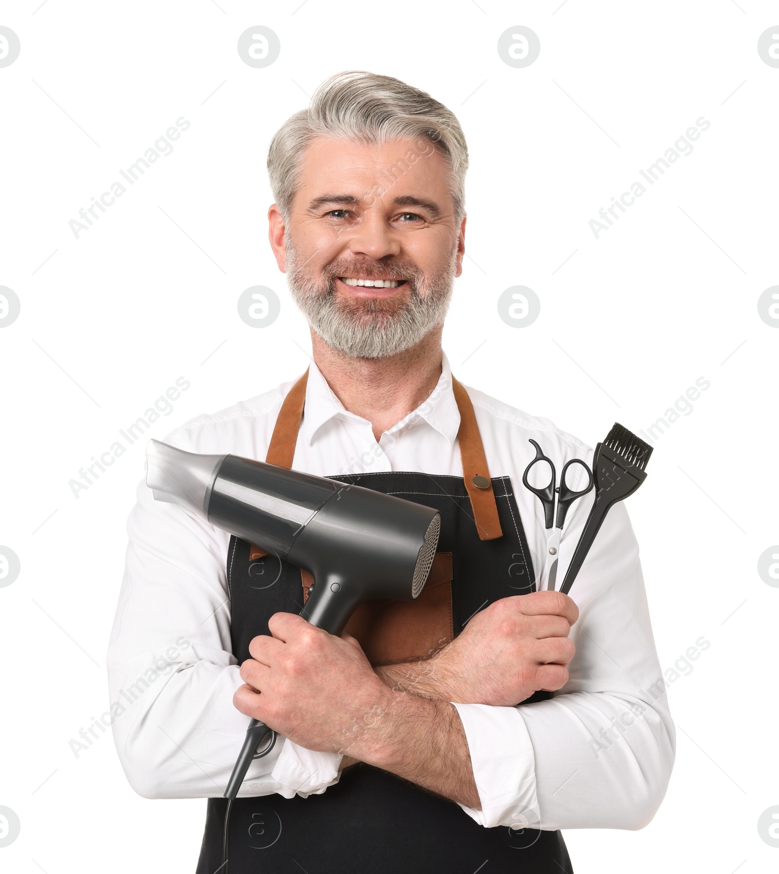 Photo of Smiling hairdresser with dryer, scissors and hair dye brush on white background