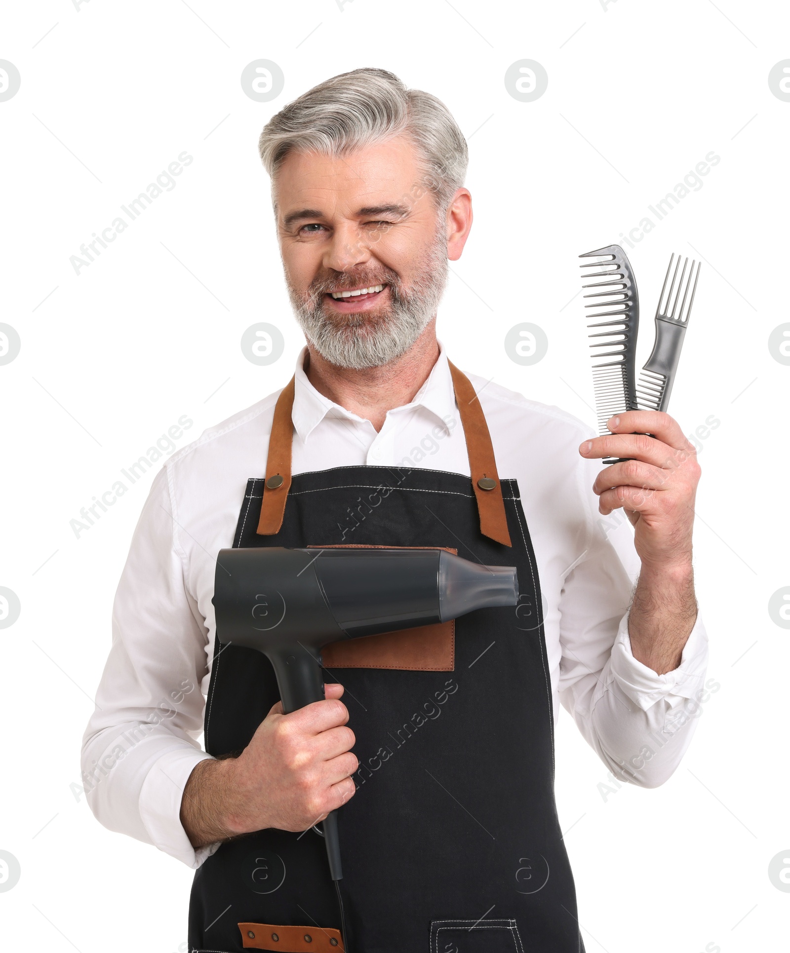 Photo of Smiling hairdresser with dryer and combs on white background