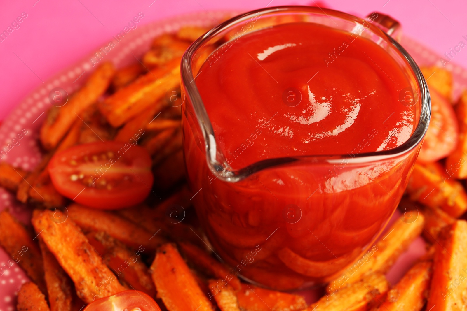 Photo of Tasty ketchup, tomatoes and fried carrots on pink background, closeup