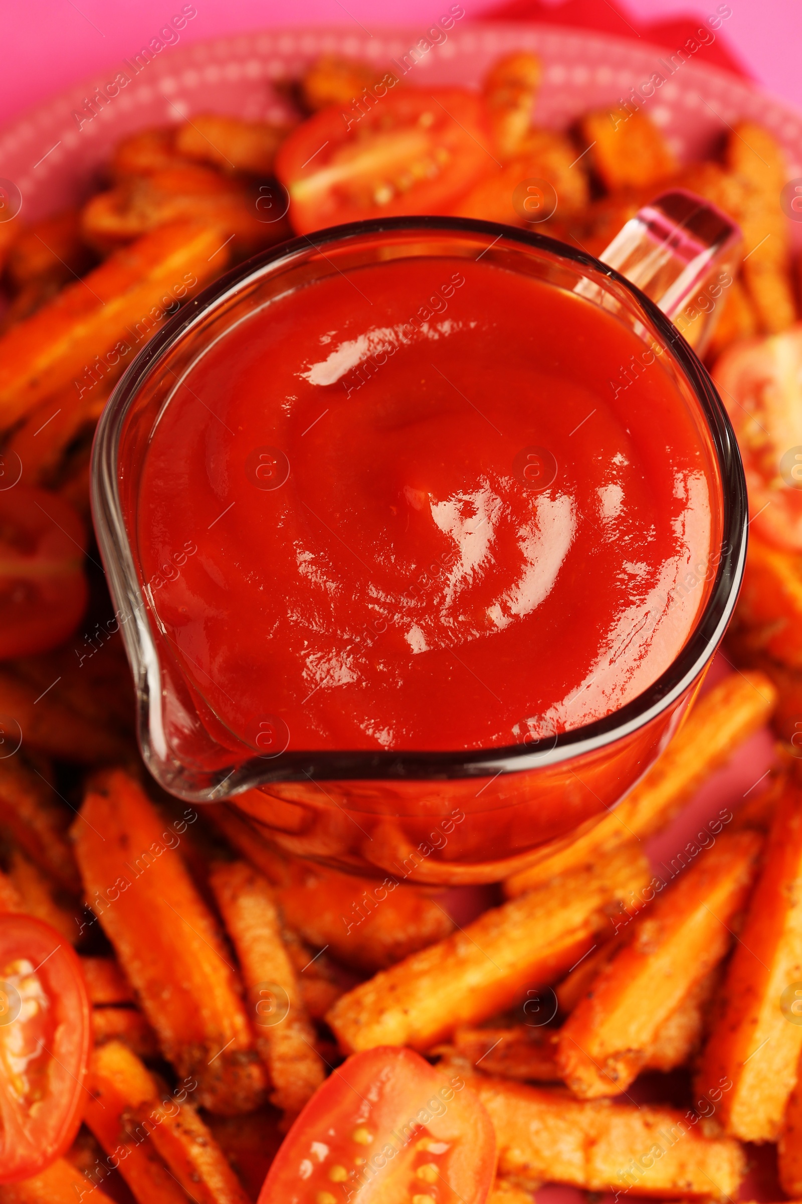 Photo of Tasty ketchup, tomatoes and fried carrots on plate, closeup